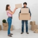 angry-man-looking-her-wife-stacking-cardboard-boxes-his-hands_23-2148095535